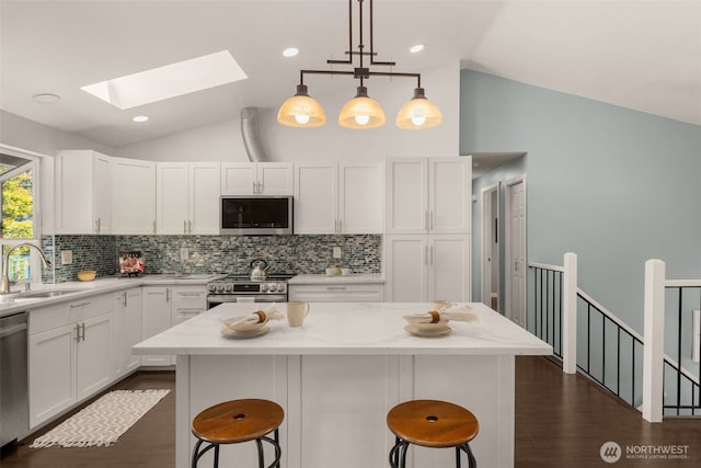 35404 18th Ave SW, Federal Way, WA 99023 - kitchen featuring stainless steel appliances, vaulted ceiling, a skylight, a breakfast bar, and decorative backsplash
