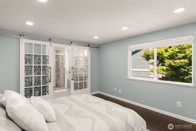 35404 18th Ave SW, Federal Way, WA 99023 - bedroom with a barn door, recessed lighting, a textured ceiling, and wood finished floors
