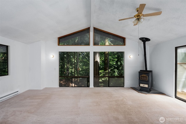 6 Hillside Pl, Bellingham, WA 98229 - unfurnished living room featuring a wood stove, carpet, lofted ceiling, a textured ceiling, and healthy amount of natural light