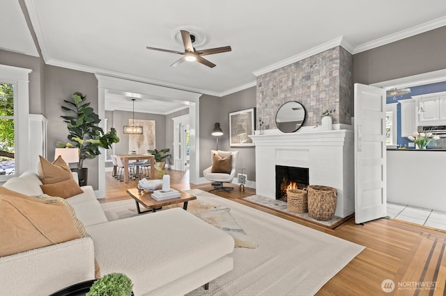 2159 10th Ave W, Seattle, WA 98119 - living room with a ceiling fan, a fireplace, light wood-style floors, and ornamental molding