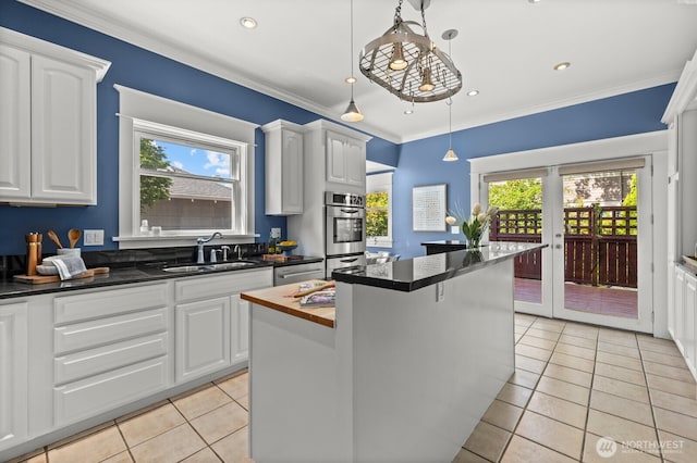 2159 10th Ave W, Seattle, WA 98119 - kitchen with light tile patterned floors, healthy amount of natural light, white cabinetry, ornamental molding, and recessed lighting