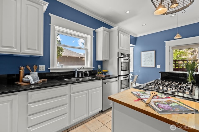 2159 10th Ave W, Seattle, WA 98119 - kitchen with appliances with stainless steel finishes, ornamental molding, white cabinets, pendant lighting, and light tile patterned flooring