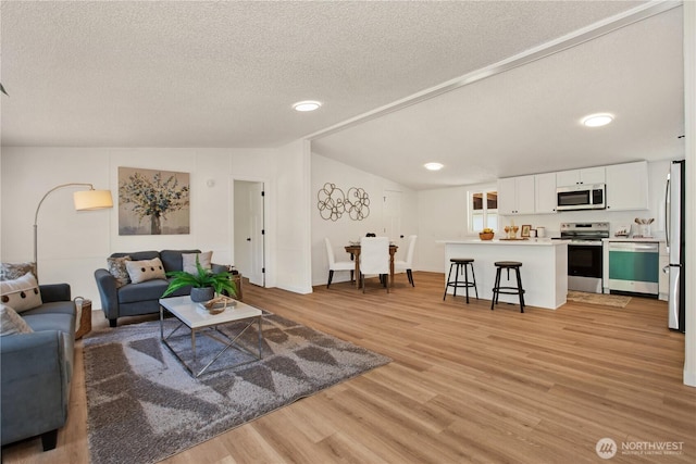 36715 Allen Rd S, Roy, WA 98580 - living room featuring light wood-style floors, a textured ceiling, vaulted ceiling, and recessed lighting