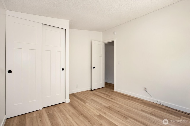 36715 Allen Rd S, Roy, WA 98580 - unfurnished bedroom featuring light wood-style flooring, a textured ceiling, and a closet