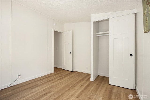 36715 Allen Rd S, Roy, WA 98580 - unfurnished bedroom with light wood-style flooring, a textured ceiling, and a closet