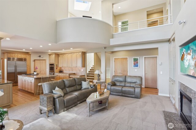 1706 205th Pl NE, Sammamish, WA 98074 - living area featuring a high ceiling, stairs, recessed lighting, a skylight, and a fireplace with flush hearth