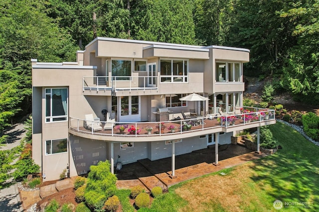 1706 205th Pl NE, Sammamish, WA 98074 - back of house with a balcony, stucco siding, a lawn, and a wooded view