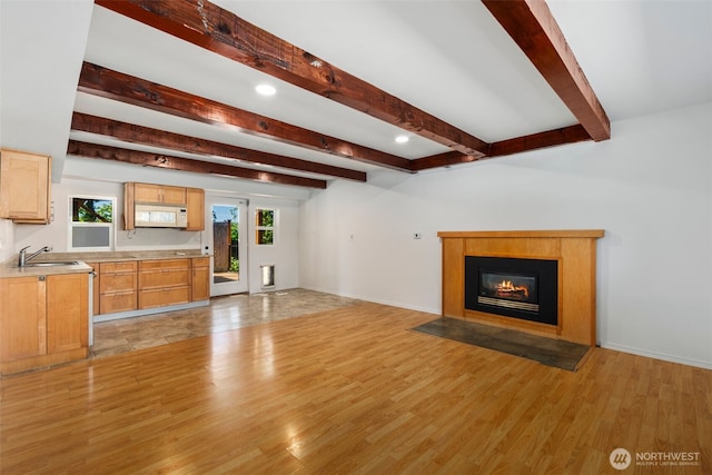 20101 95th Pl NE, Bothell, WA 98011 - unfurnished living room with light wood-style flooring, beam ceiling, and a fireplace with flush hearth
