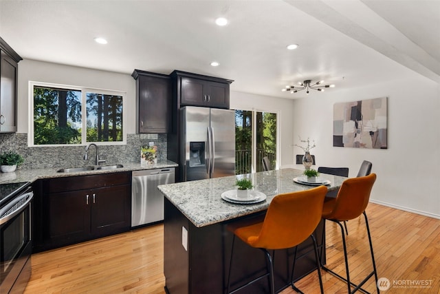 20101 95th Pl NE, Bothell, WA 98011 - kitchen featuring stainless steel appliances, tasteful backsplash, light stone countertops, light wood-style flooring, and recessed lighting
