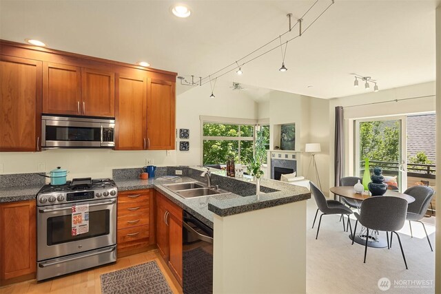 2035 Eastlake Ave E Unit 301, Seattle, WA 98102 - kitchen featuring appliances with stainless steel finishes, a peninsula, brown cabinets, plenty of natural light, and recessed lighting