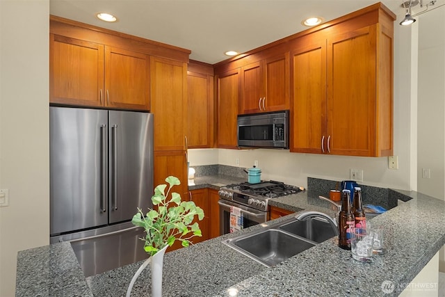 2035 Eastlake Ave E Unit 301, Seattle, WA 98102 - kitchen featuring appliances with stainless steel finishes, brown cabinets, dark stone countertops, recessed lighting, and a peninsula