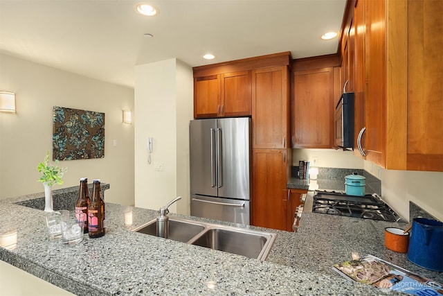 2035 Eastlake Ave E Unit 301, Seattle, WA 98102 - kitchen with appliances with stainless steel finishes, brown cabinetry, recessed lighting, a peninsula, and light stone counters