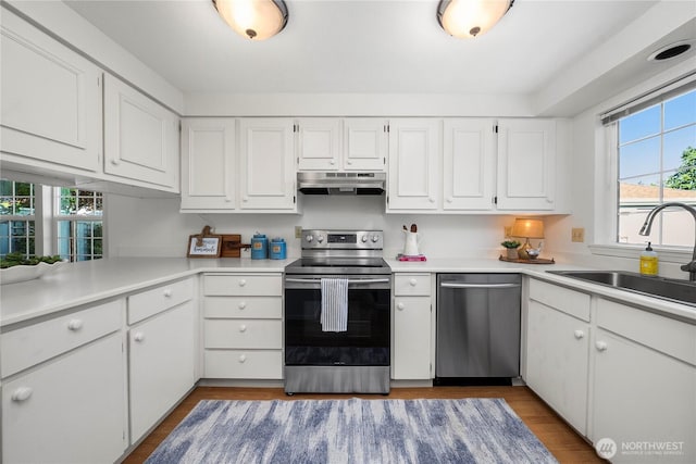 6020 N Highlands Pkwy Unit 52B, Tacoma, WA 98406 - kitchen with stainless steel appliances, under cabinet range hood, healthy amount of natural light, and white cabinetry