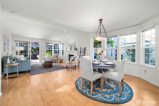 6020 N Highlands Pkwy Unit 52B, Tacoma, WA 98406 - dining area featuring healthy amount of natural light, vaulted ceiling, light wood-style flooring, and a fireplace
