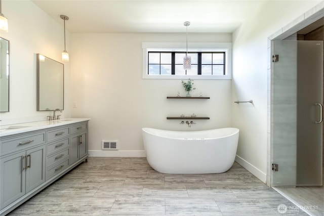 2617 Byrnes Rd, Touchet, WA 99360 - bathroom featuring double vanity, a freestanding tub, and a stall shower