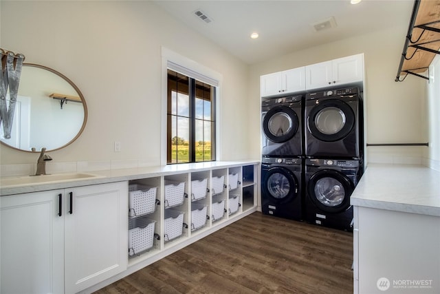 2617 Byrnes Rd, Touchet, WA 99360 - washroom featuring stacked washer / dryer, cabinet space, dark wood-style flooring, and recessed lighting