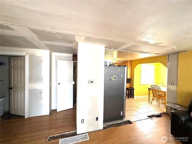 10204 19th Ave SW, Seattle, WA 98146 - kitchen featuring freestanding refrigerator, light wood-style floors, and arched walkways