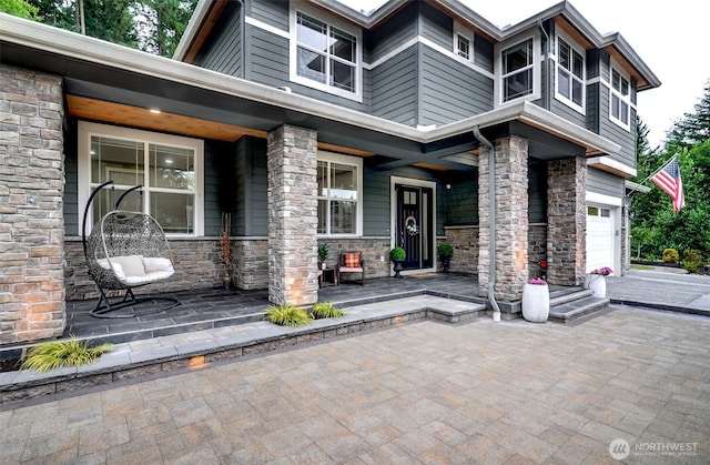 5708 197th Pl SE, Bothell, WA 98012 - view of exterior entry with a porch, stone siding, and a garage