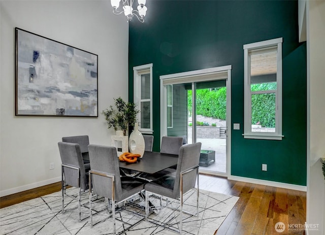 5708 197th Pl SE, Bothell, WA 98012 - dining room featuring wood-type flooring, a chandelier, and a towering ceiling