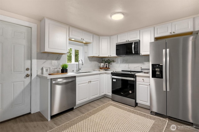 18006 116th Ave SE, Renton, WA 98058 - kitchen with appliances with stainless steel finishes, light wood finished floors, light countertops, and white cabinetry