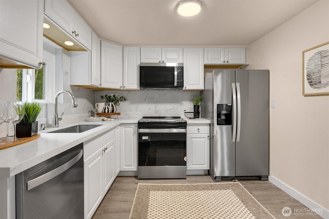 18006 116th Ave SE, Renton, WA 98058 - kitchen featuring appliances with stainless steel finishes, light wood-style flooring, white cabinetry, and light countertops