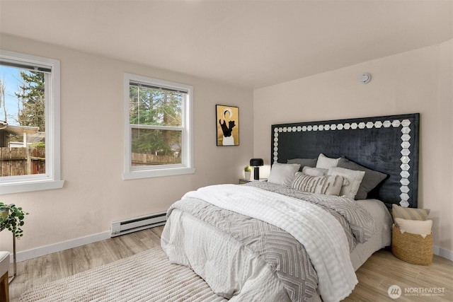 18006 116th Ave SE, Renton, WA 98058 - bedroom featuring a baseboard heating unit, wood finished floors, and multiple windows