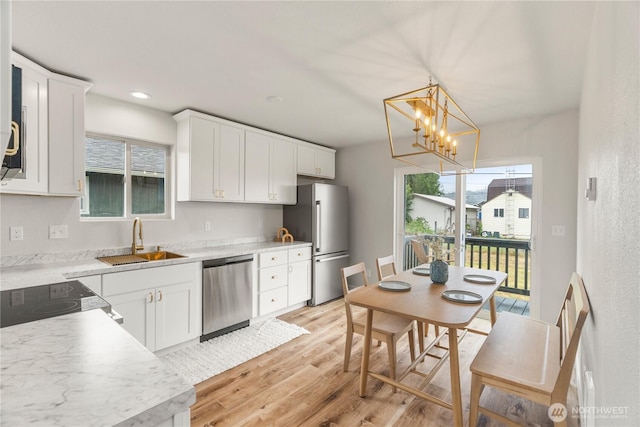 1604 W Market St, Aberdeen, WA 98520 - kitchen featuring appliances with stainless steel finishes, a chandelier, light wood-style floors, white cabinets, and plenty of natural light