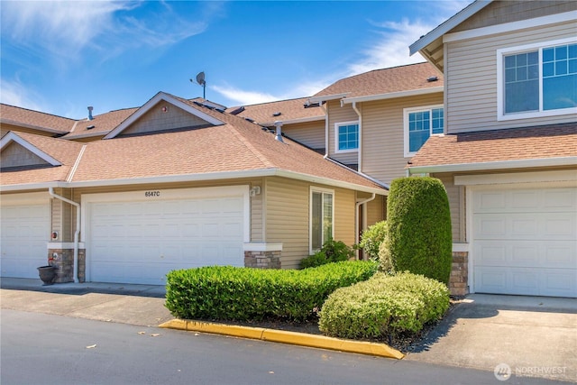 6547 Lindsay Ave SE Unit 18C, Auburn, WA 98092 - view of front of house with a shingled roof, stone siding, and driveway