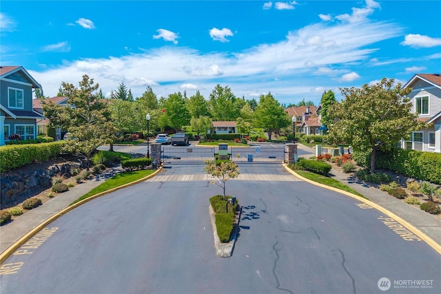 6547 Lindsay Ave SE Unit 18C, Auburn, WA 98092 - view of asphalt road featuring street lighting, a gate, a residential view, and curbs