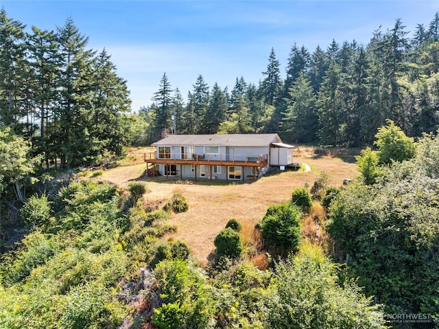 10806 W Morris Blvd, Steilacoom, WA 98388 - rear view of property with a wooden deck, a chimney, and a view of trees