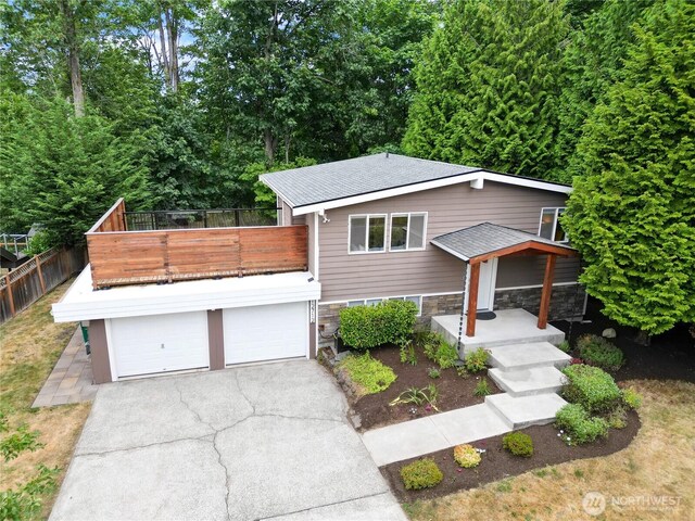 12712 NE 157th St, Woodinville, WA 98072 - view of front facade with driveway, an attached garage, a balcony, and stone siding