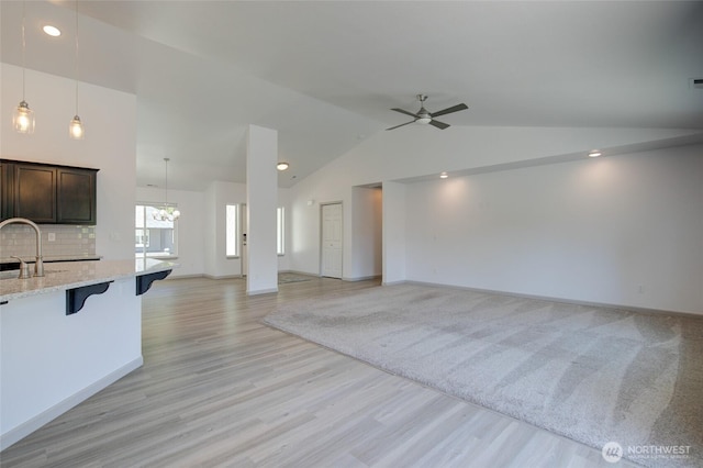 232 Jett Ct, Montesano, WA 98563 - unfurnished living room featuring vaulted ceiling, a ceiling fan, light wood-style floors, recessed lighting, and a chandelier