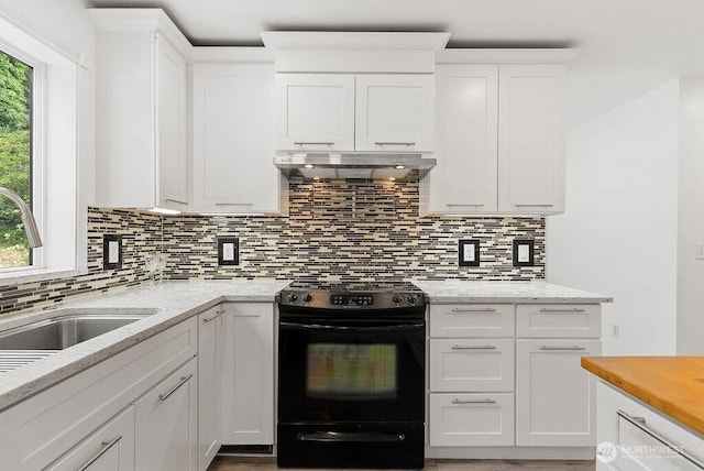 2819 SW 350th Pl, Federal Way, WA 98023 - kitchen with black range, ventilation hood, healthy amount of natural light, and white cabinets