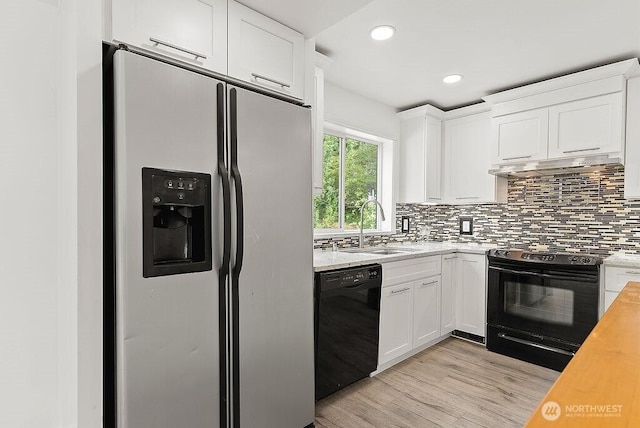 2819 SW 350th Pl, Federal Way, WA 98023 - kitchen with black appliances, under cabinet range hood, light wood-style floors, tasteful backsplash, and white cabinets