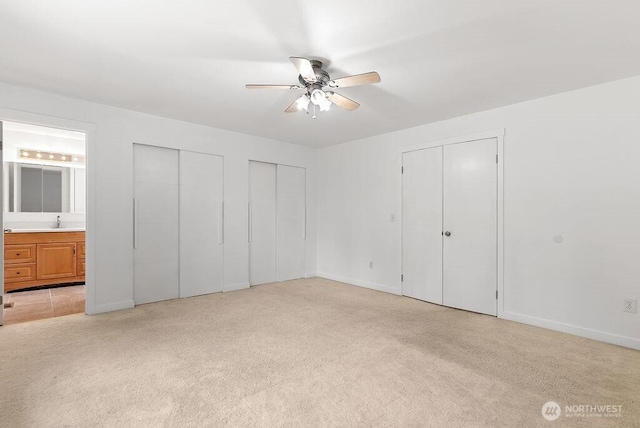 2819 SW 350th Pl, Federal Way, WA 98023 - unfurnished bedroom featuring two closets, light colored carpet, ensuite bath, and a ceiling fan