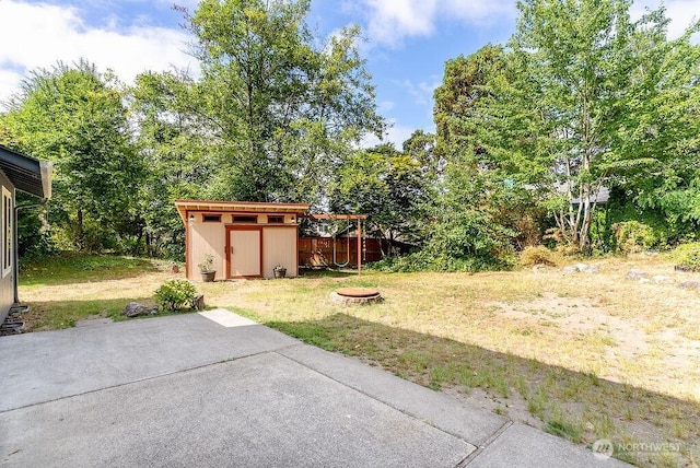 2819 SW 350th Pl, Federal Way, WA 98023 - view of green lawn featuring a storage unit, a patio, and a fire pit