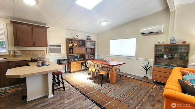 869 Mahogany Ln NW, Silverdale, WA 98383 - kitchen featuring a wall unit AC, a wall mounted air conditioner, vaulted ceiling, dark wood-type flooring, and plenty of natural light