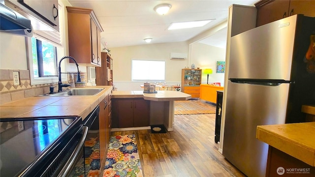 869 Mahogany Ln NW, Silverdale, WA 98383 - kitchen with range with electric cooktop, freestanding refrigerator, a peninsula, dark wood-style flooring, and plenty of natural light