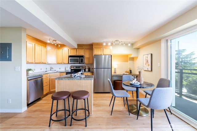 1525 Taylor Ave N Unit 505, Seattle, WA 98109 - kitchen with stainless steel appliances, track lighting, electric panel, a kitchen island, and light wood-type flooring