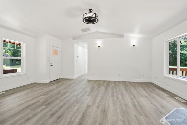 14115 Mountain Vista Dr SE, Yelm, WA 98597 - unfurnished living room featuring lofted ceiling, healthy amount of natural light, and light wood finished floors