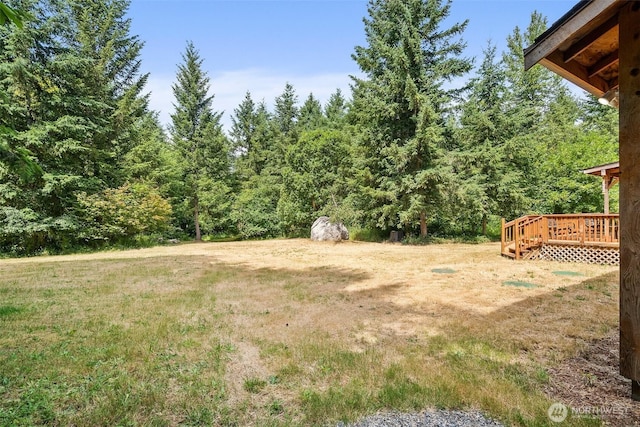 14115 Mountain Vista Dr SE, Yelm, WA 98597 - view of grassy yard with a deck and a wooded view