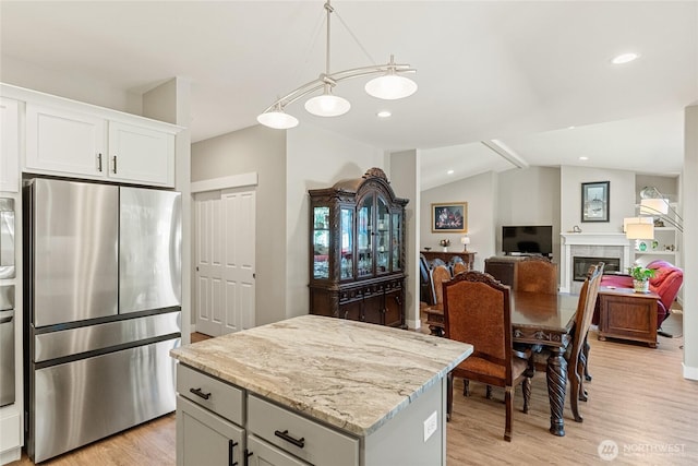 2219 Treat St SE, East Wenatchee, WA 98802 - kitchen featuring freestanding refrigerator, light wood-style flooring, a center island, light stone countertops, and recessed lighting