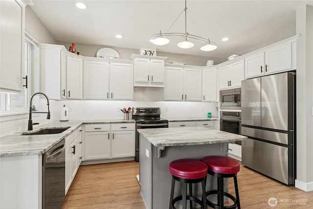 2219 Treat St SE, East Wenatchee, WA 98802 - kitchen with appliances with stainless steel finishes, white cabinets, light wood-type flooring, tasteful backsplash, and recessed lighting