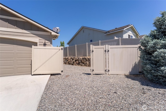 2219 Treat St SE, East Wenatchee, WA 98802 - view of home's exterior with a gate, board and batten siding, concrete driveway, and a garage