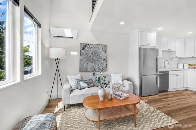 5945 41st Ave SW Unit A, Seattle, WA 98136 - living room featuring a wall unit AC, light wood-type flooring, and recessed lighting