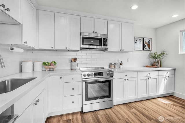5945 41st Ave SW Unit A, Seattle, WA 98136 - kitchen with stainless steel appliances, tasteful backsplash, light countertops, and recessed lighting
