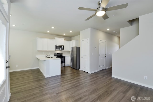 1218 E 53rd St, Tacoma, WA 98404 - kitchen featuring stainless steel appliances, a peninsula, light countertops, recessed lighting, and dark wood-style floors