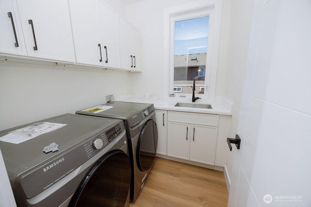 14737 56th Ave S, Tukwila, WA 98168 - laundry room with separate washer and dryer, light wood-type flooring, and cabinet space
