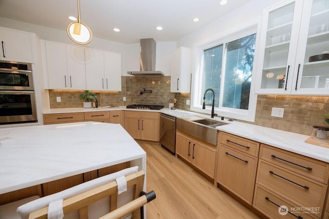 14737 56th Ave S, Tukwila, WA 98168 - kitchen featuring wall chimney range hood, appliances with stainless steel finishes, decorative backsplash, light wood finished floors, and pendant lighting