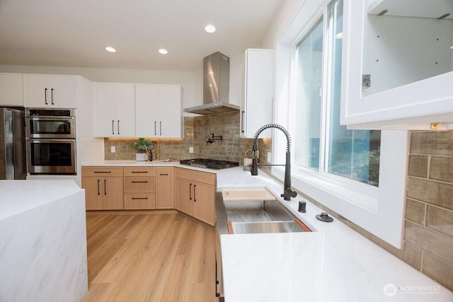 14737 56th Ave S, Tukwila, WA 98168 - kitchen with wall chimney exhaust hood, stainless steel appliances, light countertops, light wood finished floors, and decorative backsplash